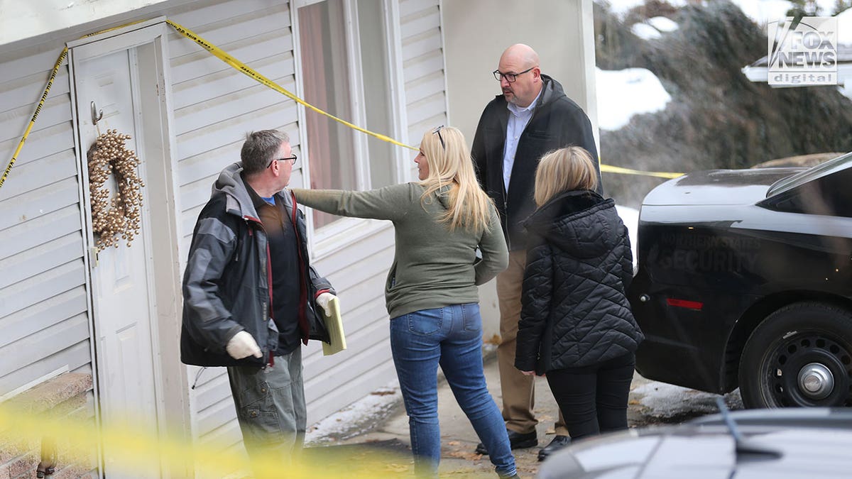 Investigators walk through snow