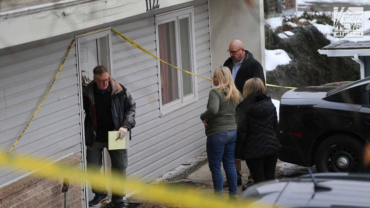 Investigators walk through snow