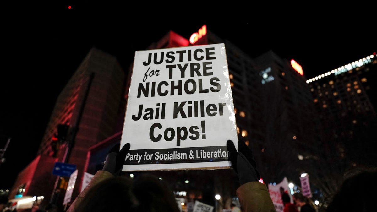 A protestor holds a sign reading "Justice for Tyre Nichols, Jail Killer Cops" during a rally against the fatal police assault of Tyre Nichols, in Atlanta, on January 27, 2023