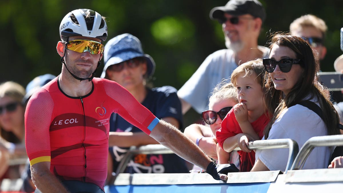 Mark Cavendish cycling next to family