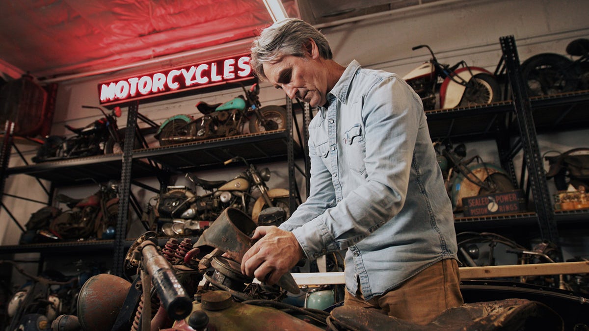mike wolfe working on a motorcycle