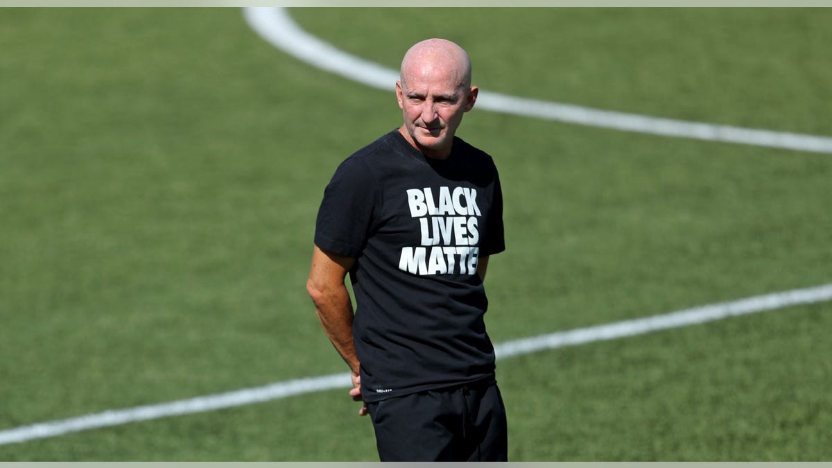Paul Riley looks on
