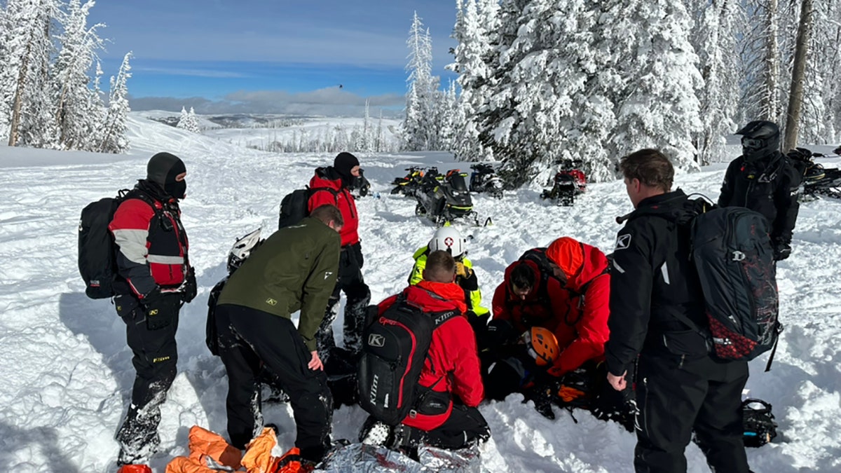 rescuers aiding injured man on mountain