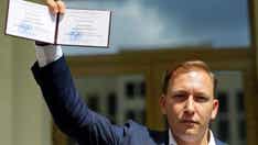 Belarusian investigators use photo of politician shaking hands with Hillary Clinton against him