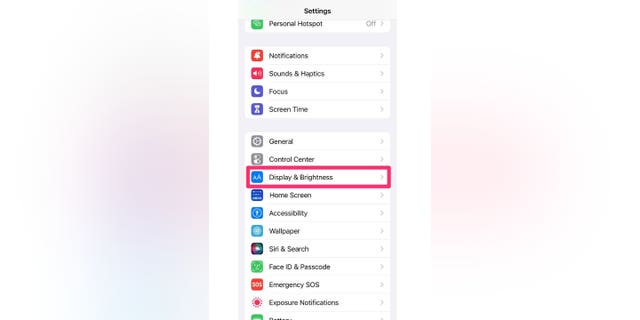 Tangkapan layar petunjuk tentang cara memilih Tampilan & Kecerahan dari layar Pengaturan. Ada cara untuk mempermudah membaca dengan mengubah ukuran font di iPhone.