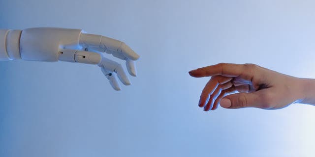 Manusia &  Robot Hand membuat ulang karya Michelangelo "Penciptaan Adam" Lukisan