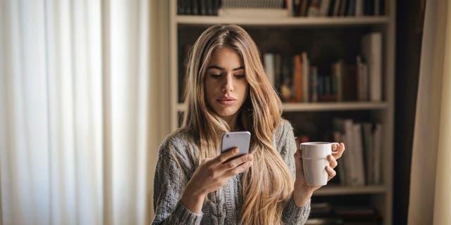 Women are looking at her iPhone.