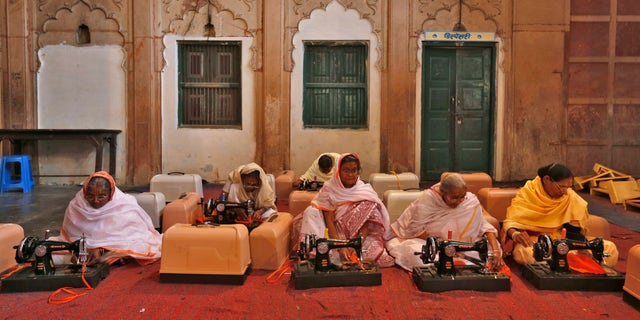 Para janda dengan mesin jahit mereka menghadiri kelas pelatihan di ashram Meera Sahavagini di kota ziarah Vrindavan di negara bagian Uttar Pradesh, India utara, 6 Maret 2013. 