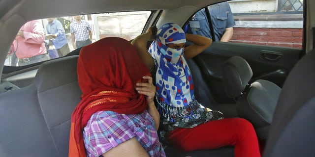 Two veiled Nepali women, who told police they were raped by a Saudi official, sit in a vehicle outside Nepal's embassy in New Delhi, India, September 9, 2015. The two women, aged 30 and 50, told police they were raped, assaulted, starved and held hostage over several months after leaving Nepal to work for the official. 