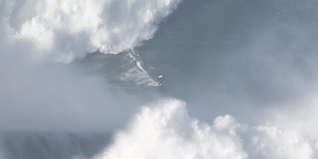 A surfer rides a wave in Praia do Norte, Nazare, Portugal, Jan. 8, 2022. 