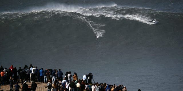 A surfer rides a wave in Praia do Norte, Nazare, Portugal, February 25, 2022. 