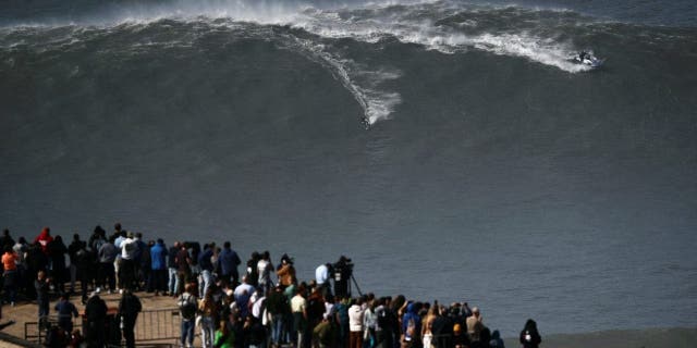 A surfer rides a wave in Praia do Norte, Nazare, Portugal, February 25, 2022.