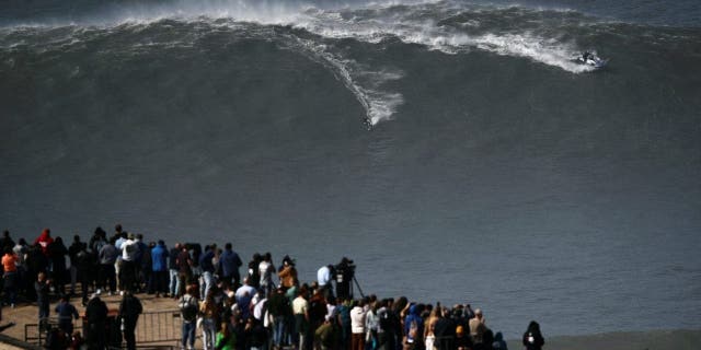 A surfer rides a wave in Praia do Norte, Nazare, Portugal, on February 25, 2022. 