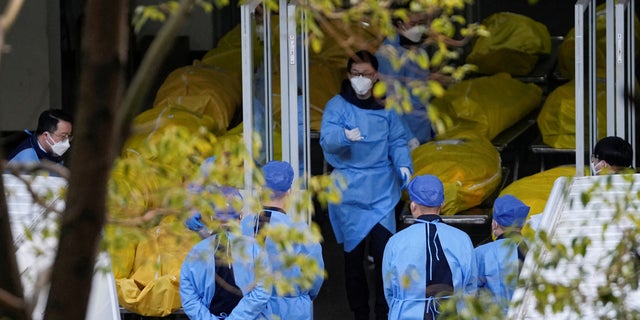 A staff member walks next to several body bags at a funeral home, as COVID-19 outbreaks continue in Shanghai, China, January 4, 2023.