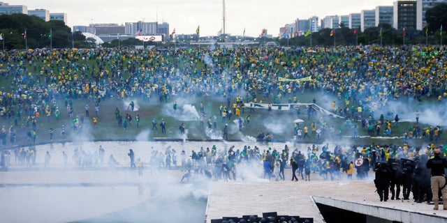 Pendukung mantan Presiden Brasil Jair Bolsonaro berdemonstrasi menentang Presiden Luiz Inacio Lula da Silva saat pasukan keamanan beroperasi, di luar Kongres Nasional Brasil di Brasilia, Brasil, 8 Januari 2023.