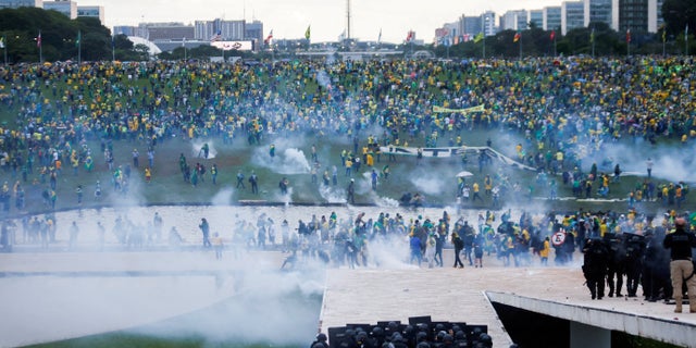 Supporters of Brazil's former President Jair Bolsonaro demonstrate against President Luiz Inacio Lula da Silva as security forces operate, outside Brazil's National Congress in Brasilia, Brazil, Jan. 8, 2023.