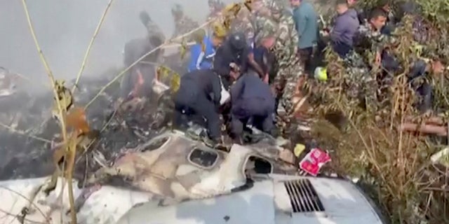 Rescuers work at the site of a plane crash in Pokhara, Nepal January 15, 2023, in this screen grab taken from a handout video. (ANI/Handout/via REUTERS)