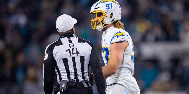 El apoyador de los Chargers de Los Ángeles, Joey Bosa, habla con el árbitro de la NFL, Shawn Smith, durante un partido contra los Jacksonville Jaguars en un partido de playoffs comodín en el TIAA Bank Field. 