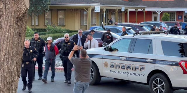 Police officers detain a man, believed by law enforcement to be the Half Moon Bay mass shooting suspect, in Half Moon Bay, California, Jan. 23, 2023, in this screengrab taken from a social media video. 