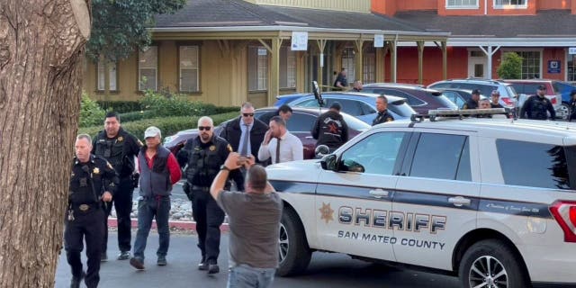 Police officers detain a man, believed by law enforcement to be the Half Moon Bay mass shooting suspect, in Half Moon Bay, California, Jan. 23, 2023, in this screengrab taken from a social media video.