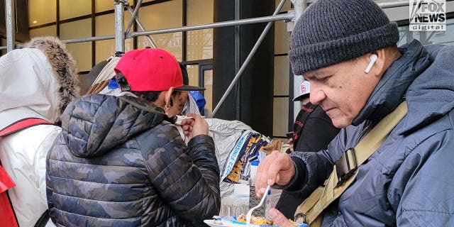 Migrants are seen outside the Watson Hotel in Midtown Manhattan, Monday, Jan. 30, 2023.