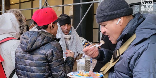 Migrants are seen outside the Watson Hotel in Midtown Manhattan, Monday, Jan. 30, 2023.