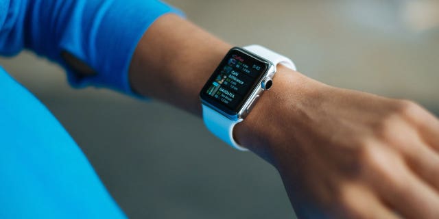 A woman wears an Apple Watch and looks for a place to buy coffee.