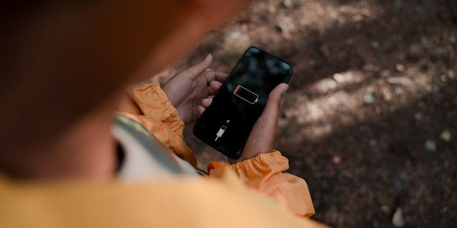 Person holding phone with low battery