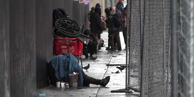 Drug users and dealers occupy a bus stop in San Francisco.