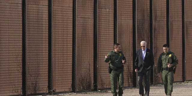 President Joe Biden loopt met agenten van de Amerikaanse grenspatrouille langs het grensgebied tussen de VS en Mexico in El Paso, Texas, zondag 8 januari 2023. 