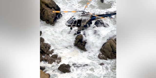 This image from video provided by San Mateo County Sheriff's Office shows a helicopter rescue after a Tesla plunged off a Northern California cliff along the Pacific Coast Highway, Monday, Jan. 2, 2023, near an area known as Devil's Slide, leaving four people in critical condition, a fire official said. 