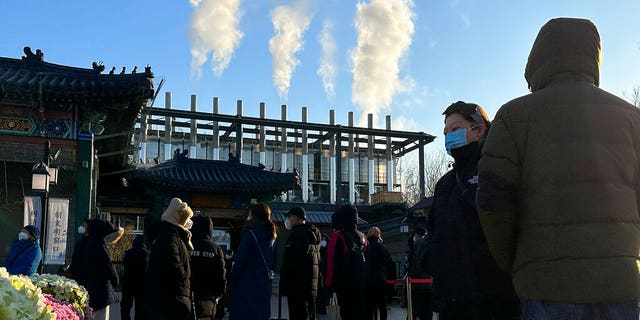 Mourners stand outside a crematorium in Beijing on December 31, 2022.