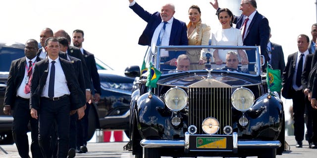 President-elect Luiz Inacio Lula da Silva, left, his wife Rosangela Silva, second from left, Vice President-elect Geraldo Alckmin, right, and his wife Maria Lucia Ribeiro, ride on an open car to Congress for their swearing-in ceremony, in Brasilia, Brazil, Sunday, Jan. 1, 2023. 