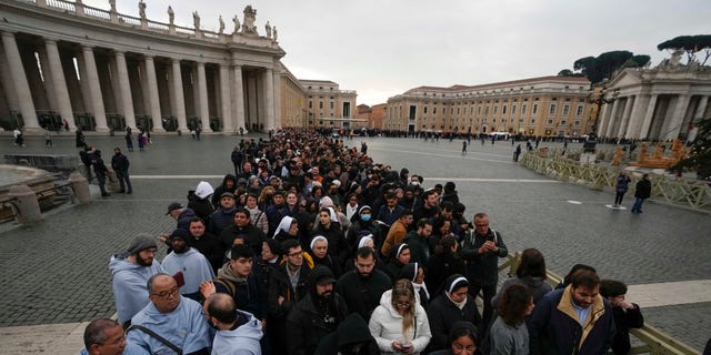 People wait in a line to enter Saint Peter's Basilica at the Vatican where late Pope Emeritus Benedict XVI is being laid in state at The Vatican, Monday, Jan. 2, 2023.