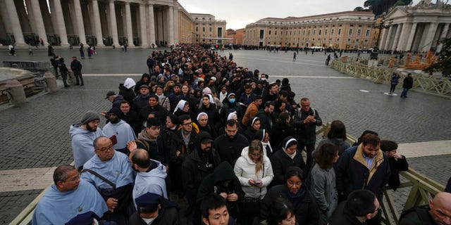 People wait in a line to enter Saint Peter's Basilica at the Vatican where late Pope Emeritus Benedict XVI is being laid in state at The Vatican, Monday, Jan. 2, 2023.