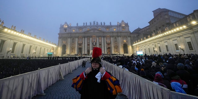 A guard stands as the fog covers the St. Peter's Basilica Dome in St. Peter's Square at the Vatican ahead of the funeral mass for late Pope Emeritus Benedict XVI, Thursday, Jan. 5, 2023. 