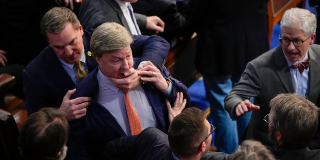 Rep. Richard Hudson, R-N.C., left, pulls Rep. Mike Rogers, R-Ala., back as they talk with Rep. Matt Gaetz, R-Fla., and other during the 14th round of voting for speaker as the House meets for the fourth day to try and elect a speaker and convene the 118th Congress in Washington, Friday, Jan. 6, 2023. 