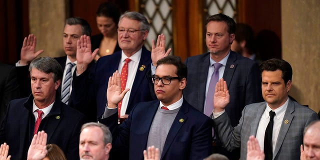 Rep. George Santos, R-N.Y., center, and Rep. Matt Gaetz, R-Fla., right, are sworn in by Speaker of the House Kevin McCarthy of California as members of the 118th Congress in Washington, D.C., early Saturday. 