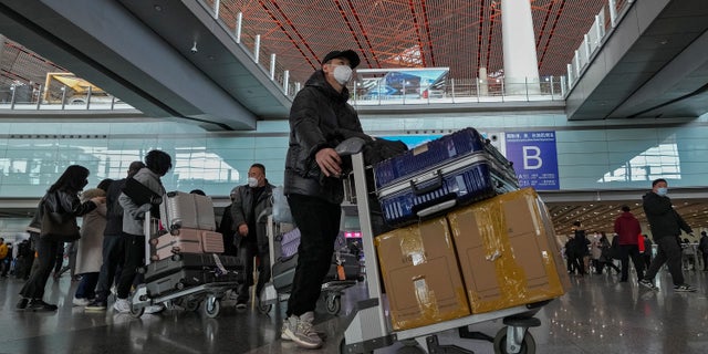 Penumpang dari Hong Kong tiba di aula kedatangan internasional Terminal 3 Bandara Internasional Ibukota Beijing di Beijing, Minggu, 8 Januari 2023.