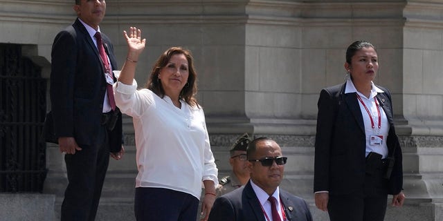 Em meio à segurança, a presidente peruana Dina Bolorati acena para a imprensa do lado de fora do Palácio do Governo enquanto o primeiro-ministro Alberto Otarola sai em Lima, Peru, terça-feira, 10 de janeiro de 2023. 