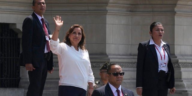 Em meio à segurança, a presidente peruana Dina Bolorati acena para a imprensa do lado de fora do Palácio do Governo enquanto o primeiro-ministro Alberto Otarola sai em Lima, Peru, terça-feira, 10 de janeiro de 2023. 