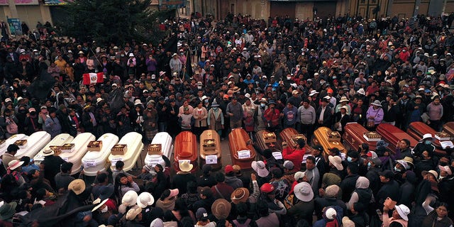 2023 年 1 月 10 日火曜日、ペルーのフリアカで起きた暴動で亡くなった 12 人以上の人々の追悼集会で、棺を囲む住民たち。