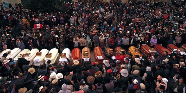 Residents surround coffins during a vigil for the more than a dozen people who died during the unrest in Juliaca, Peru, Tuesday, Jan. 10, 2023.
