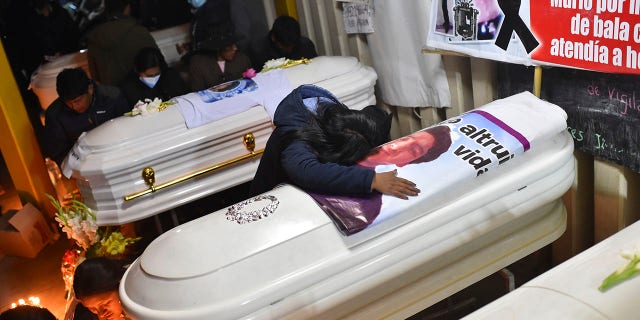 A woman cries over a coffin containing the remains of her friend Antonio Samillan who died during the unrest in Juliaca, Peru, Tuesday, Jan. 10, 2023.