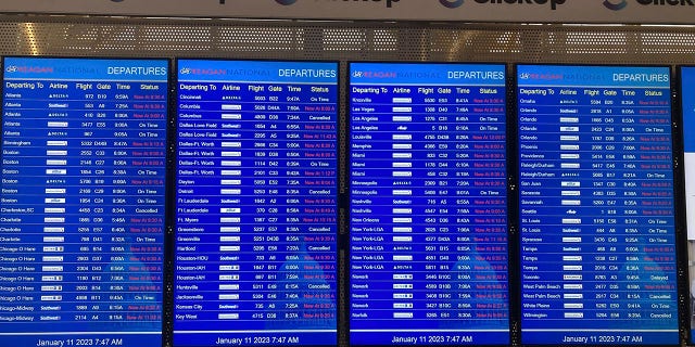 A message board shows departures at Ronald Reagan Washington National Airport in Arlington, Va., on Wednesday, Jan. 11. 2023. 