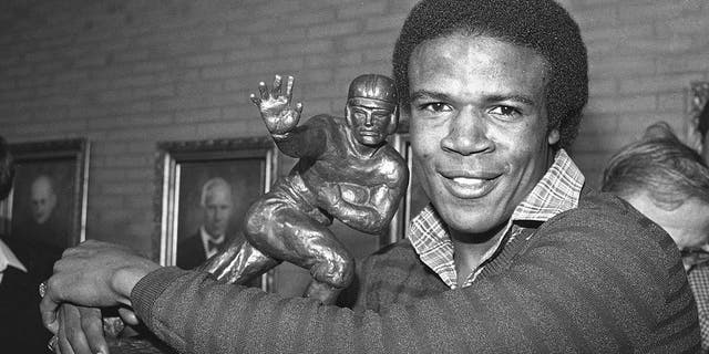 Southern California tailback Charles White puts his arms around the Heisman Trophy won by O.J. Simpson in 1968 after White was announced as the winner of the 1979 Heisman Trophy, Dec. 3, 1979, in Los Angeles. 