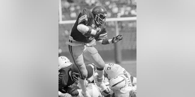 El corredor del sur de California, Charles White (12), hace un primer intento contra Stanford durante un partido de fútbol americano universitario de la NCAA en Los Ángeles, el 13 de octubre de 1979. 