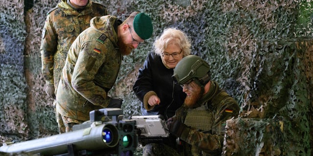 Forer German Defense Minister Christine Lambrecht talk with soldiers during a presentation at the 'Erzgebirgskaserne' barracks in Marienberg, Eastern Germany, Thursday, Jan. 12, 2023. 