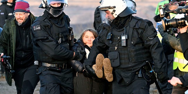 Politieagenten dragen de Zweedse klimaatactiviste Greta Thunberg weg van de rand van de Garzweiler II open bruinkoolmijn tijdens een protestactie van klimaatactivisten na de ontruiming van Luetzerath, Duitsland, dinsdag 17 januari 2023. 