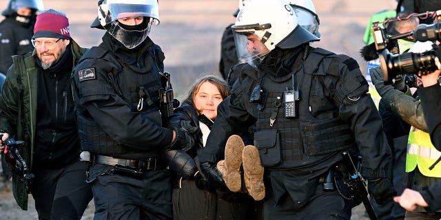 Police officers carry Swedish climate activist Greta Thunberg away from the edge of the Garzweiler II opencast lignite mine during a protest action by climate activists after the clearance of Luetzerath, Germany, Tuesday, Jan. 17, 2023.